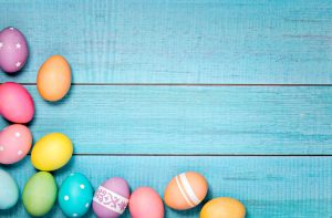 Colorful Easter Eggs arranged on a blue background.